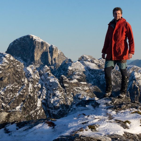 Michael Cooper in front of snow covered peaks, Western Tasmania